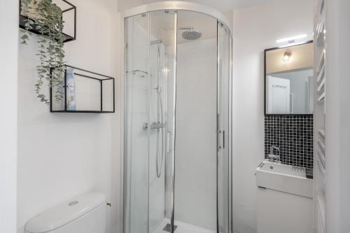 une salle de bain avec une douche en verre et un lavabo dans l'établissement Élégant appartement à quelques pas de la plage, à Pornichet
