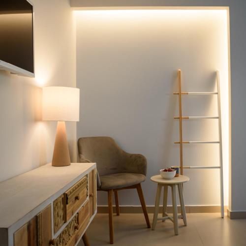 a room with a chair and a table with a lamp at Ambeli Luxury Villa in Megalokhori