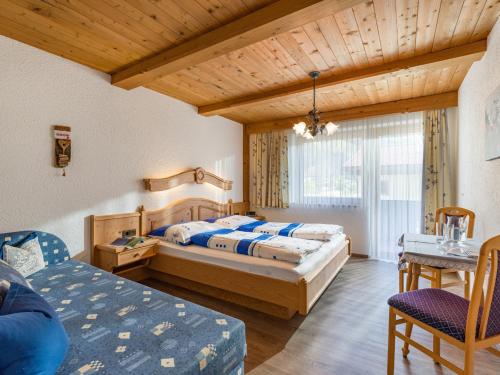 a bedroom with two beds and a couch and a table at Gästehaus Geisler in Hippach