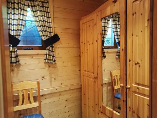 a log cabin with two windows and two chairs at Apartments Helsen in Mühlbach am Hochkönig