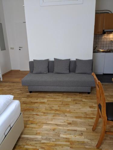 een woonkamer met een bank en een houten vloer bij 108 Studio Apartment Alexandria 30m2 in Klagenfurt