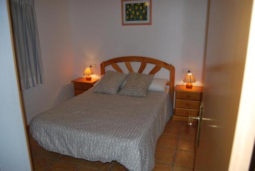 a bedroom with a bed and two lamps on two night stands at Apartamentos Les Moreres in Duesaigües