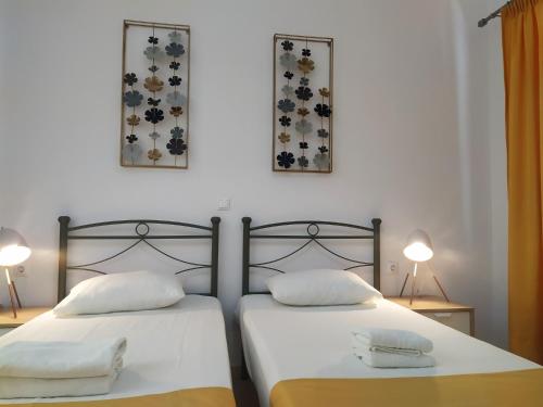 two beds sitting next to each other in a bedroom at Aronis Apartments in Benitses