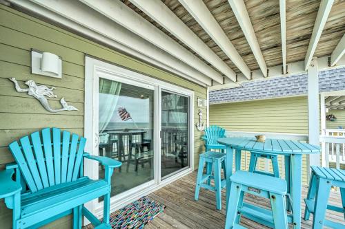 a patio with blue chairs and a table on a porch at Ocean Dunes Kure Beach Condo with Balcony and Pool in Kure Beach