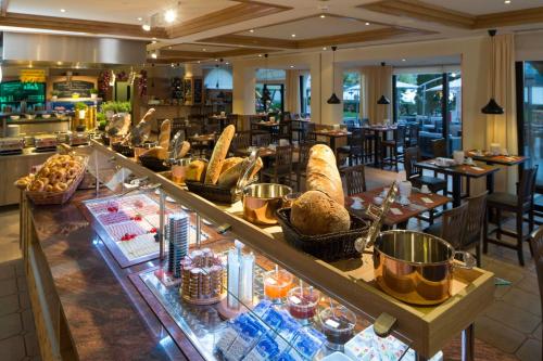 a restaurant with a buffet line with food on display at H4 Hotel Arcadia Locarno in Locarno