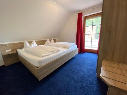 a bedroom with a large white bed with a window at Untersee - Appartements in Moos