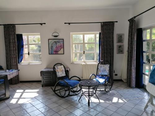 マリーナ・ディ・モーディカにあるVilla Sikaniaのリビングルーム(椅子、テーブル、窓付)
