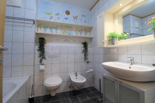 łazienka z umywalką, toaletą i wanną w obiekcie Family Apartment FUCHS Bad Kleinkirchheim w mieście Bad Kleinkirchheim
