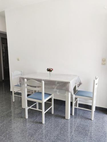 a white table with two chairs and a vase on it at Atrium Apartment #2 in Karpathos Town