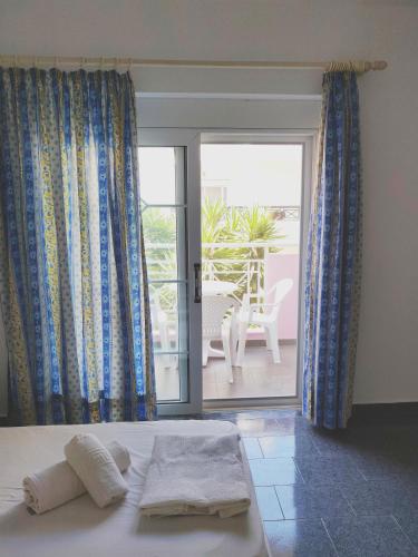 a bedroom with a bed and a view of a patio at Atrium Apartment #2 in Karpathos Town