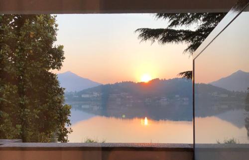 a view from a window of a lake at sunset at Hotel Chalet del Lago in Avigliana