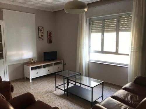 een woonkamer met een bank, een tafel en een televisie bij Casa de la Abuela in Fabero