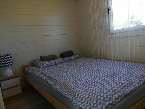 a bedroom with a bed in a room with a window at Domek LENA in Giżycko