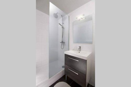 biała łazienka z umywalką i prysznicem w obiekcie R-Appartements La Petite Strasbourgeoise Hygge studio cosy centre-ville Strasbourg w Strasburgu
