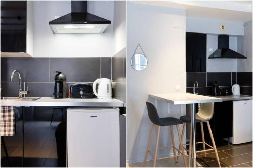 une cuisine avec des armoires blanches et un comptoir avec des tabourets dans l'établissement R-Appartements Strasbourg La Petite Strasbourgeoise Hygge studio cosy, à Strasbourg