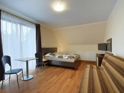 a room with a bed and a table and chairs at Dafne 2 in Niechorze