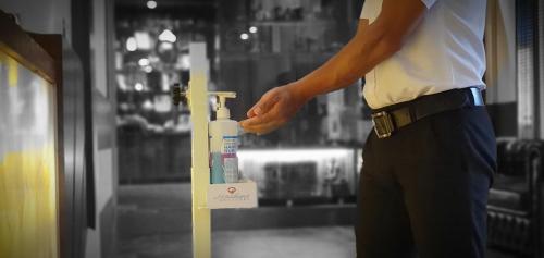 a man is standing next to a bottle of bleach at Quartz Himalayan Brothers in Dharamshala