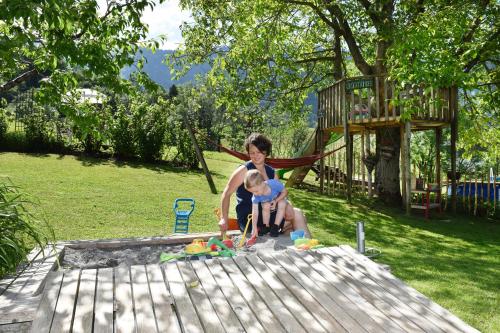 a woman and a child playing in a sandbox at Familienbauernhof Köss Schertler in Egg