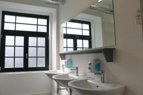 a bathroom with a sink, mirror and tub at Nice Way Porto Hostel in Porto