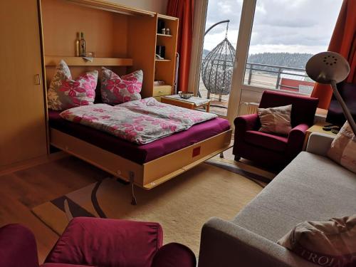 ザンクト・エングルマールにある2 Raum Ferienwohnung Sonnenscheinのベッドルーム(ベッド1台付)、バルコニーが備わります。
