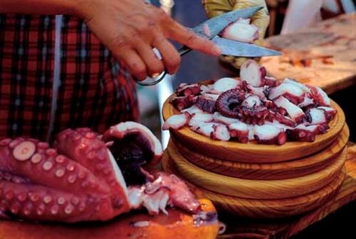 a person is cutting a cake with a knife at Motel Cancun Barbadas-Ourense in Os Fornos