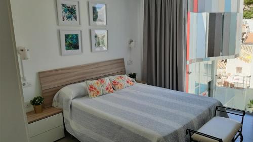 niewielka sypialnia z łóżkiem i oknem w obiekcie Casita celeste w mieście Jaén