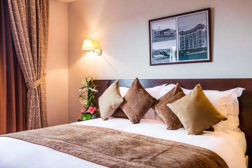 een hotelkamer met een bed met kussens bij Relax Hotel Airport Nouasseur in Nouaseur