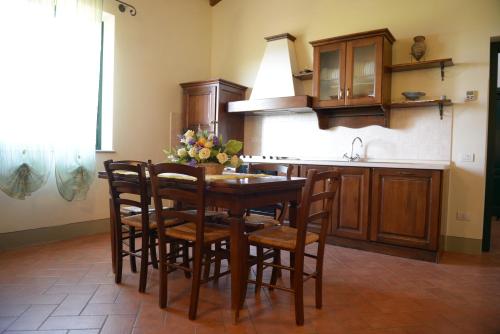 a kitchen with a wooden table and some chairs at Agriturismo Musignano in Cerreto Guidi