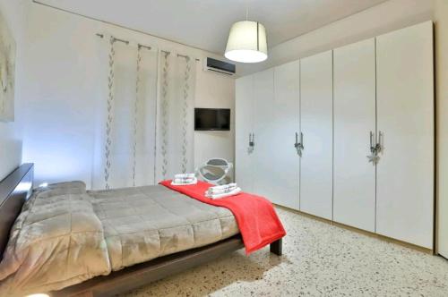 Casa vacanza Arcangeli في ساليرنو: غرفة نوم بسرير وبطانية حمراء ودواليب بيضاء