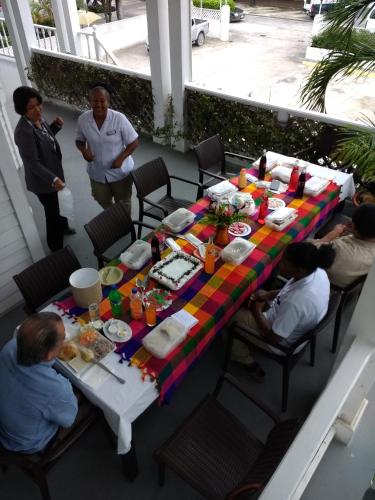 a group of people sitting around a table with food at The Great House Inn in Belize City