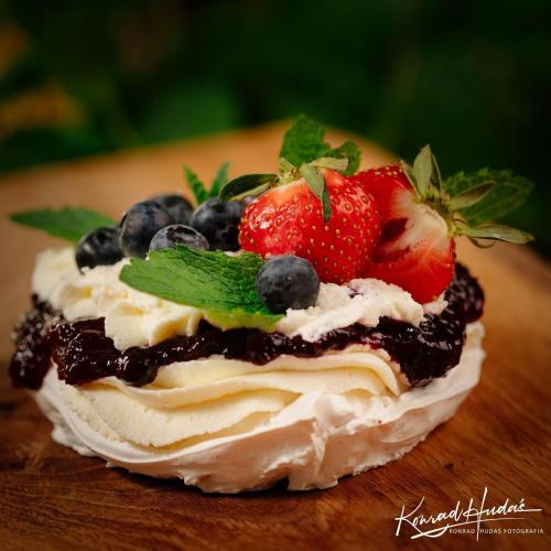 a dessert with strawberries and blueberries on a wooden table at Hotel President in Kock