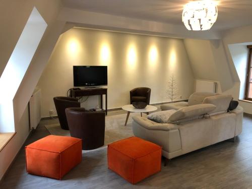a living room with a couch and a tv at Hotel La Croix De Vernuche in Varennes Vauzelles