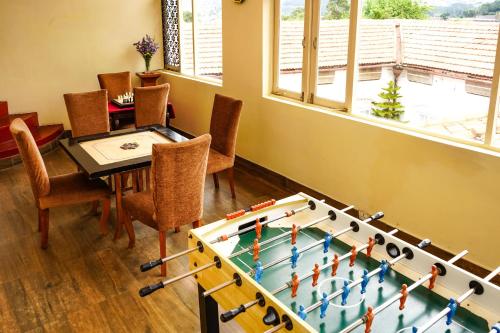 a living room with a table and a game board at Gateway Coonoor in Coonoor