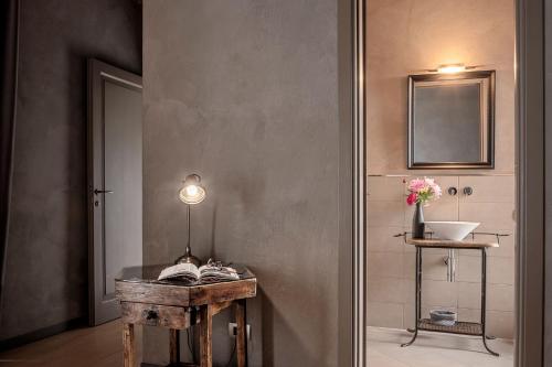 a bathroom with a sink and a table with a mirror at Agriresort Villa Gelso- Adults Friendly in Vesime