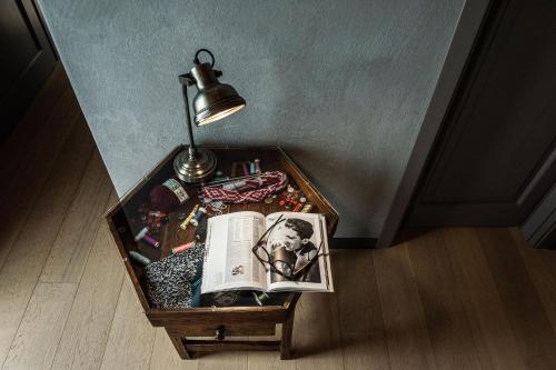 a table with a lamp and a book on it at Agriresort Villa Gelso- Adults Friendly in Vesime