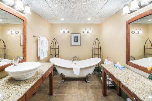 a bathroom with two sinks and a large tub at Ramada by Wyndham Thunder Bay Airlane Hotel in Thunder Bay
