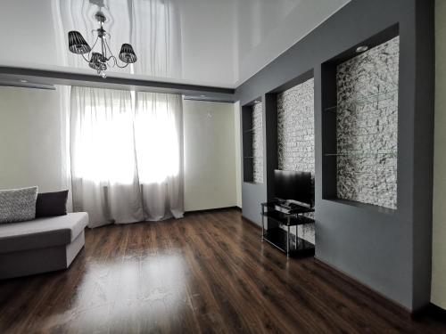 a living room with a couch and a television at Lavina apartments in Sumy