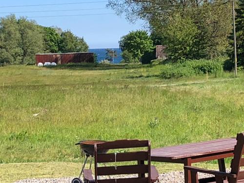 a picnic table and a bench in a field at FAXESTUGORNA in Abbekås