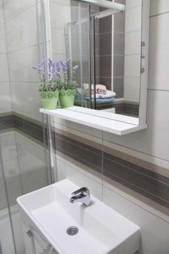 a bathroom with a sink and a mirror at Apartmani Matea in Cres