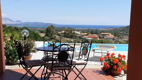 a patio with a table and chairs and a pool at Li Muntigeddi in San Teodoro