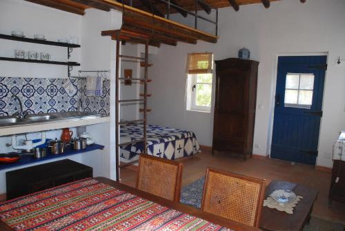 a room with a bedroom with a bunk bed and a table at Montes de Baixo in Odeceixe