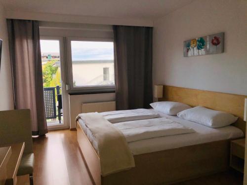 a bedroom with a bed and a large window at Haus Pannonsee in Podersdorf am See