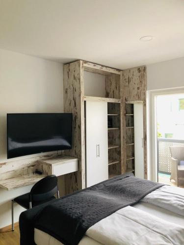 a bedroom with a bed and a desk with a television at Haus Pannonsee in Podersdorf am See