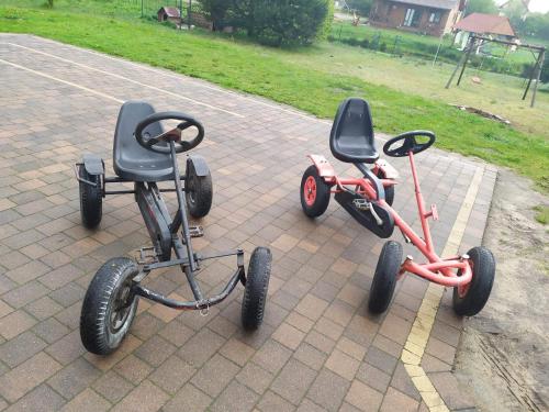 two tricycles are parked on a brick sidewalk at Kaszuby wczasy u Danusi sauna i bania in Lipusz
