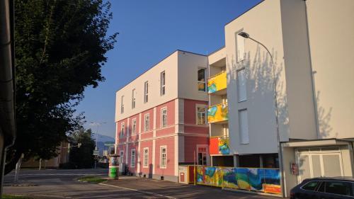 a building with colorful paintings on it next to a street at 108 Studio Apartment Alexandria 30m2 in Klagenfurt