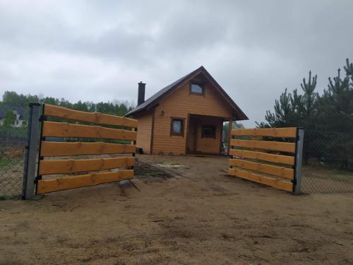 two wooden fences in front of a house at Kaszuby wczasy u Danusi sauna i bania in Lipusz
