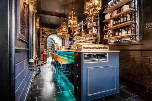 een bar met een blauwe bar en enkele stoelen bij Castelsuites in Brugge