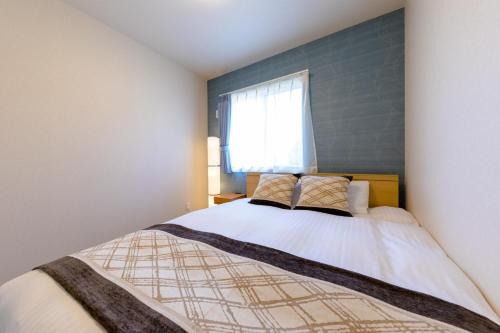 um quarto com uma cama grande e uma janela em Minamitsuru-gun - House - Vacation STAY 82677 em Fujikawaguchiko