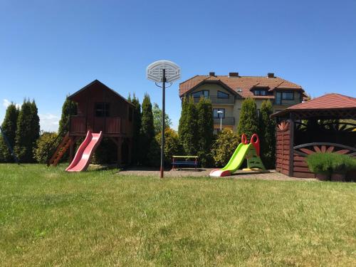a park with a playground with a slide at Domki Letniskowe Błękit in Jastrzębia Góra