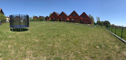 a large yard with a playground in front of a house at Domki Letniskowe Błękit in Jastrzębia Góra